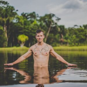 Male guest at a Caya Shobo Ayahuasca Retreat takes a dip in an Amazonian lagoon near the healing center, Iquitos, Peru